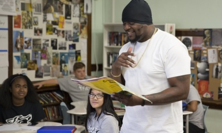 Youth program founder hurt in shooting 'has biggest heart': black man in black beanie reading happily to a classroom of students