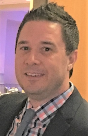 Daniel Vollrath headshot: white man in jacket, tie and plaid shirt