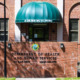 Foster care lawsuit: Red brick building with green entry stoop canopy and black letter signage "Department of Health and Human Services"