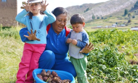 Native community food system improvement grants: happy Native mother and her two children gathering food in field