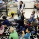 US teacher shortage, HBCU helping to change that: young female teacher of color teaching classroom of children with hands raised