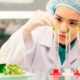 Native youth food and agricultural education grants: young female researcher putting plants into test tubes with liquid