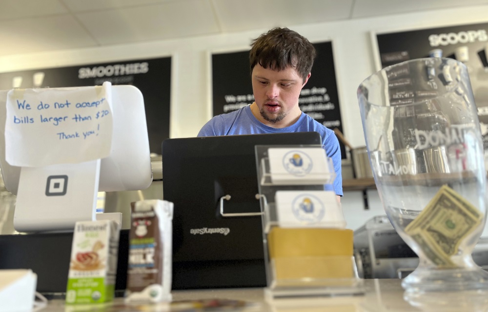 youth with autism and epilepsy transition to adulthood: young man with disability in blue shirt working at counter of store