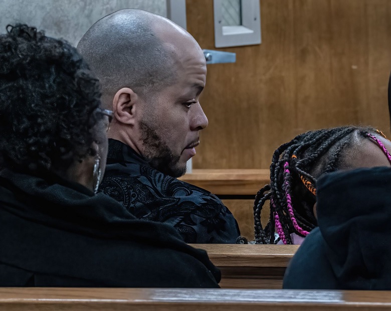 Kids taken from Black family remain in state custody: man with shaved head and facial hair looks to his right at black girl with colorful beads in hair