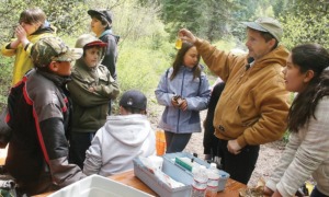 Northwest Native-American community grants: group of youths learning about environment outdoors from educator