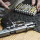Gun injury increase: Close up of a black and silver handgun lies next to a box of nearly 100 bullets on a table