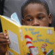 Reading: Yung Black boy reading Dr. Stess book he holds in front of his face