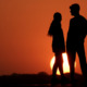 Teen sex: Two people are silhouetted against a deep orange sky as the sun sets