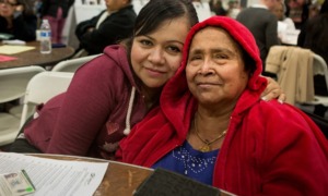 Silicon Valley region disadvantaged community action grants: younger and older women of color smiling for camera at community event