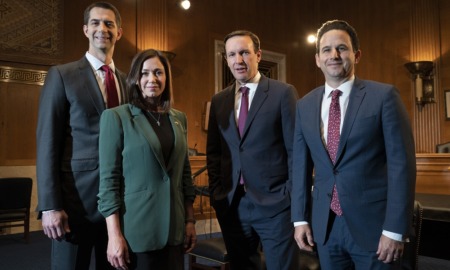Social media ban for kids in Senate: three men and a woman in a suit inside government building standing and smiling at camera