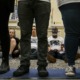 DeSantis signs bills targeting LGBTQ+: people sitting on the ground looking through legs of people standing