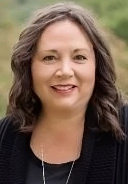 Vickie Bradley headshot: woman with longer brown hair outdoors in dark sweater