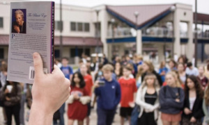 Book bans: a copy of "The Bluest Eye" is held in front of a group of students.