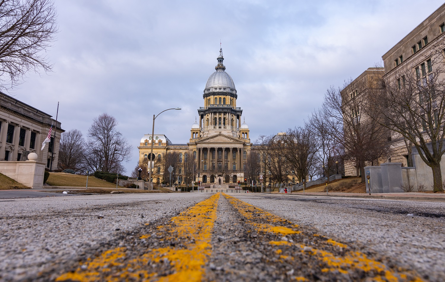 Illinois budget worsened foster care crisis: view of Illinois state capitol from rough road leading up to it.