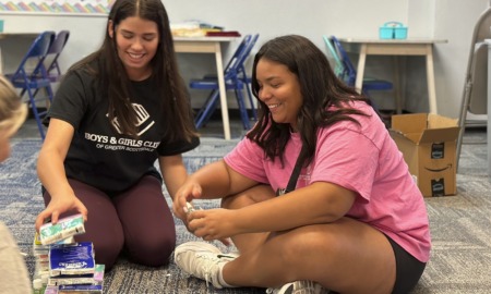 Summer camps are booming: two young women workers on floor smiling while stacking things