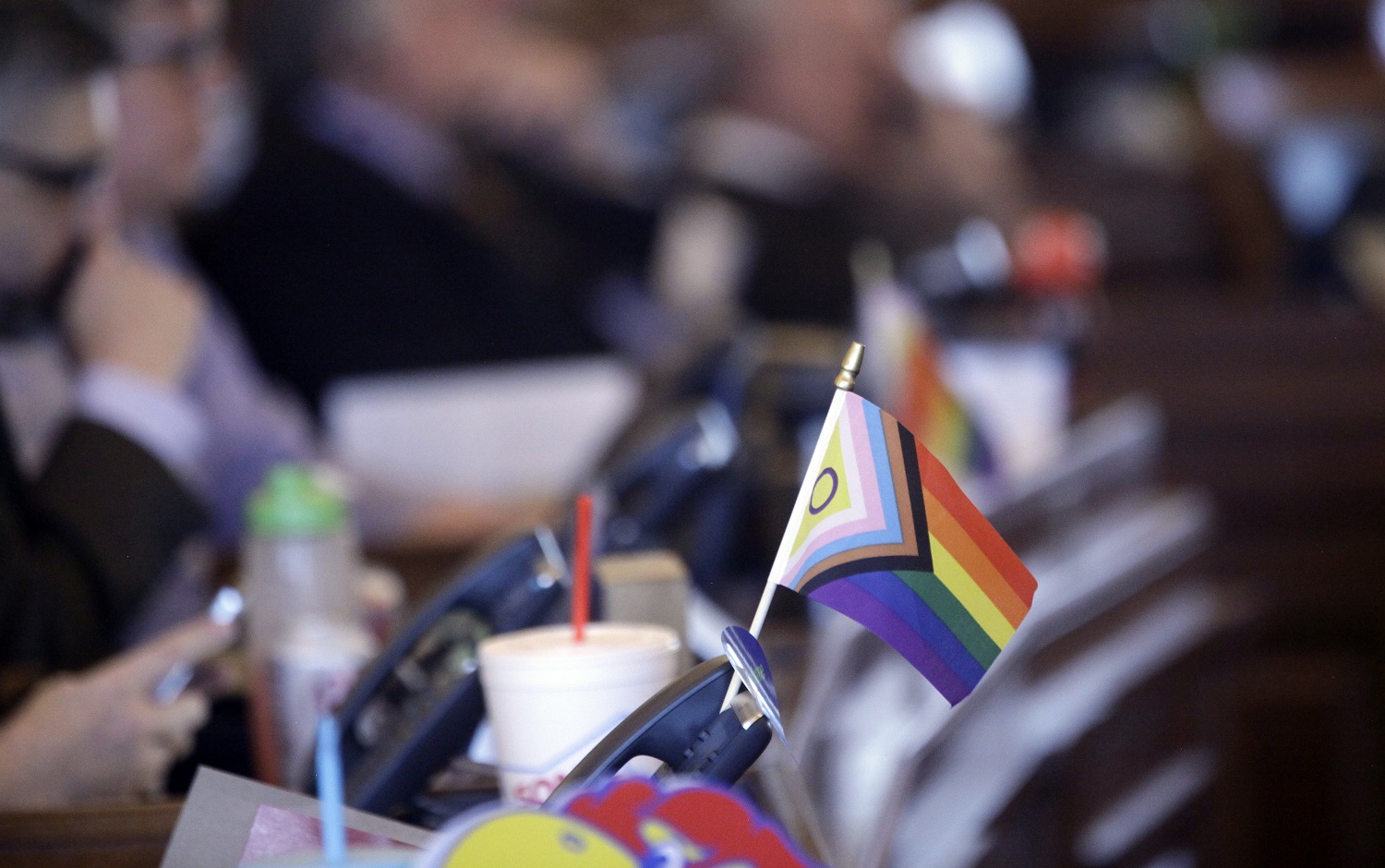 Law on bathroom and trans kids enforcement: LGBTQ rights flag sits on desk of legislator in statehouse