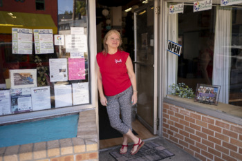Youth homelessness: A person in a red shirt and gray pants leans against an entryway