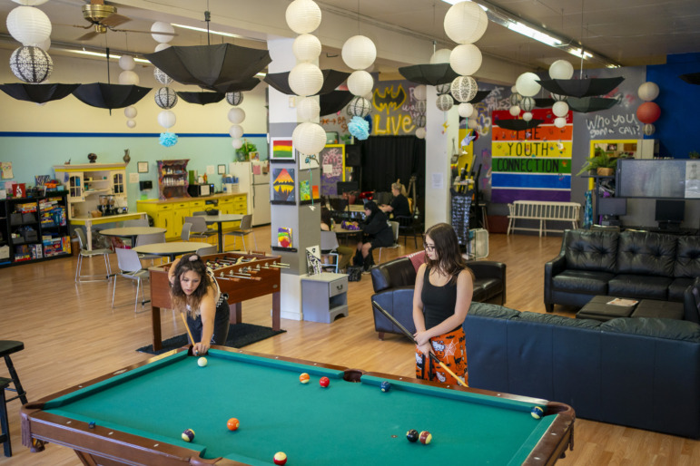 Youth homelessness: Two people play pool in a colorfully decorated room