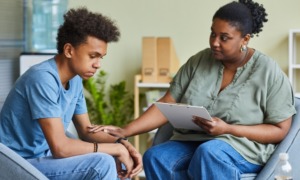 Black youth mental health and suicide: Black teen being helped by black woman psychologist
