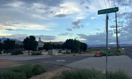 Diamond Ranch Shutdown: Several buildings surrounded by trees at the intersection of intersetrion of two roads under a blue sky with gray and white clouds.