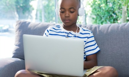 child/youth internet safety improvement grants: young black boy on laptop with headphones on