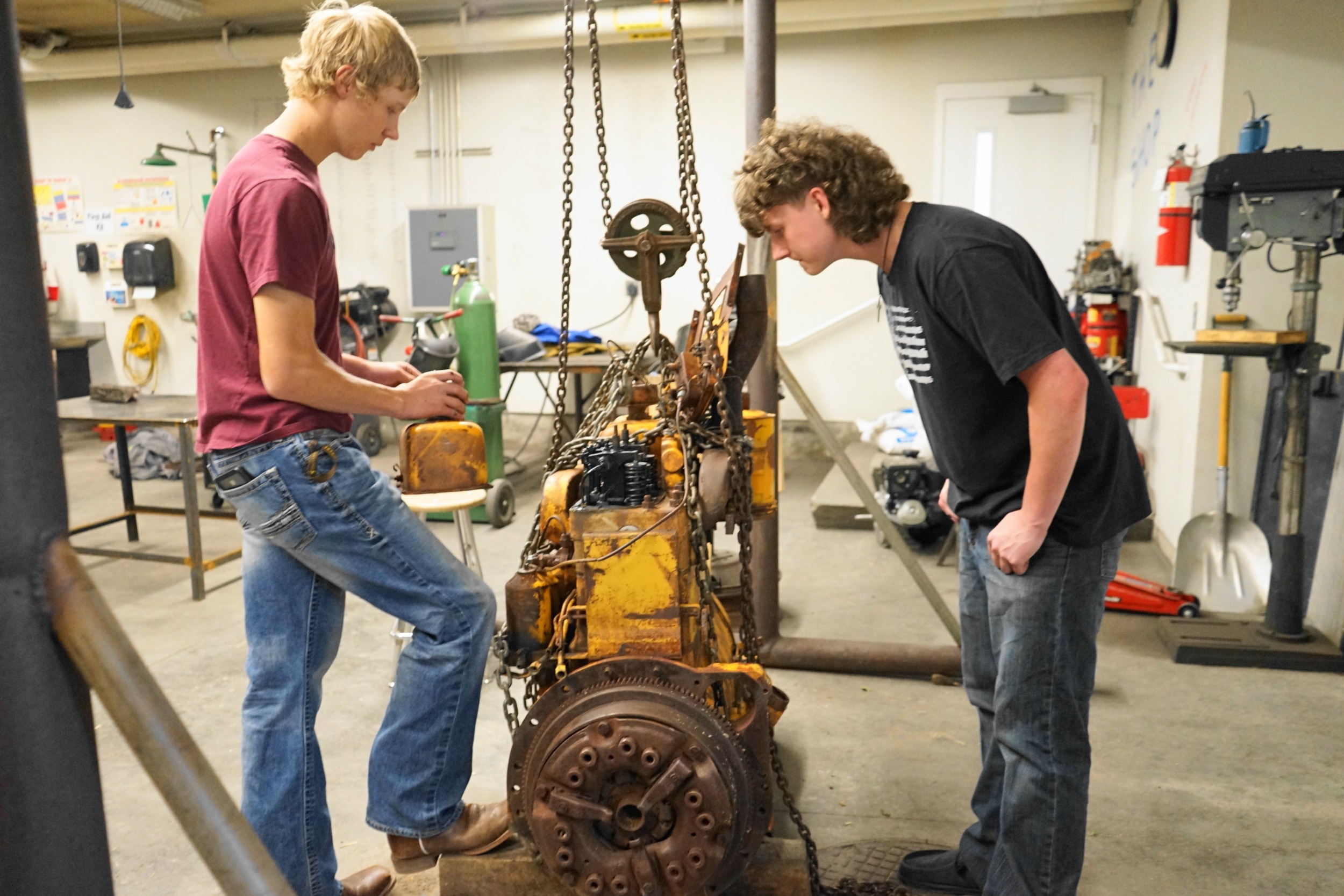 Chugwater, WY public school is now charter: two young students working on an engine in workshop