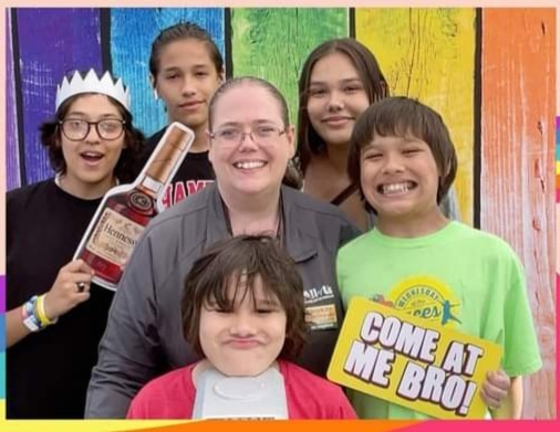 US schools now offer help with hunger, housing, healthcare: woman with children grouped around her in front of colorful background