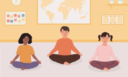 School wellness rooms: Elementary school kids doing yoga in classroom. Smiling children sitting in floor with closed eyes and crossed legs meditating.