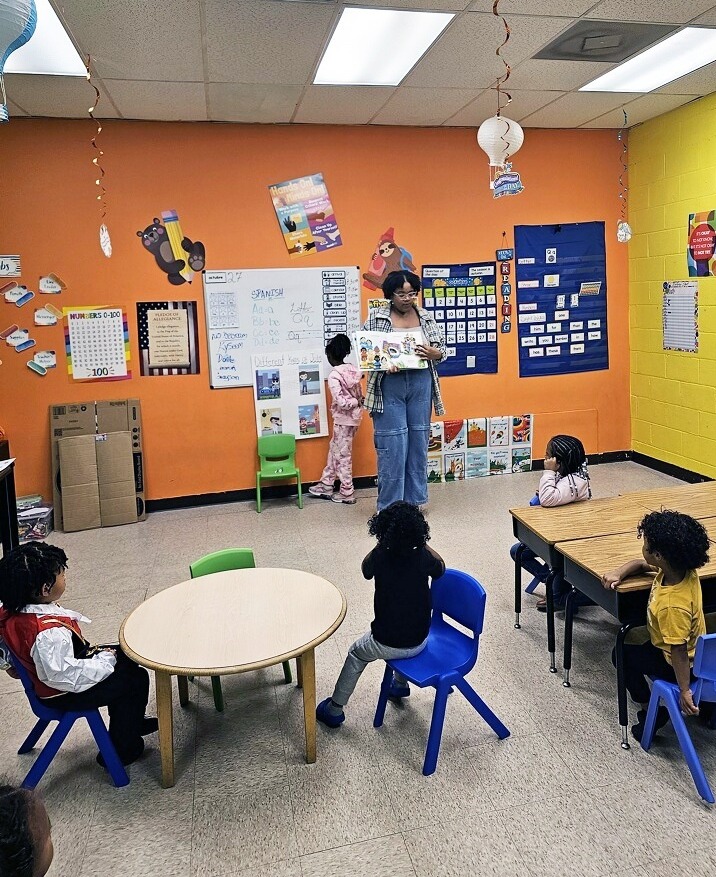 Daycare owners and parents at a breaking point: colorful classroom with teacher standing in front talking to children
