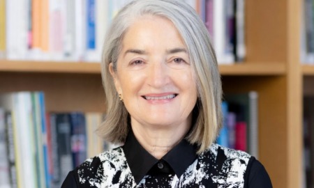 Ellen Alberding steps down from Joyce Foundation: older white woman with mid-length gray hair smiling in front of book-shelves