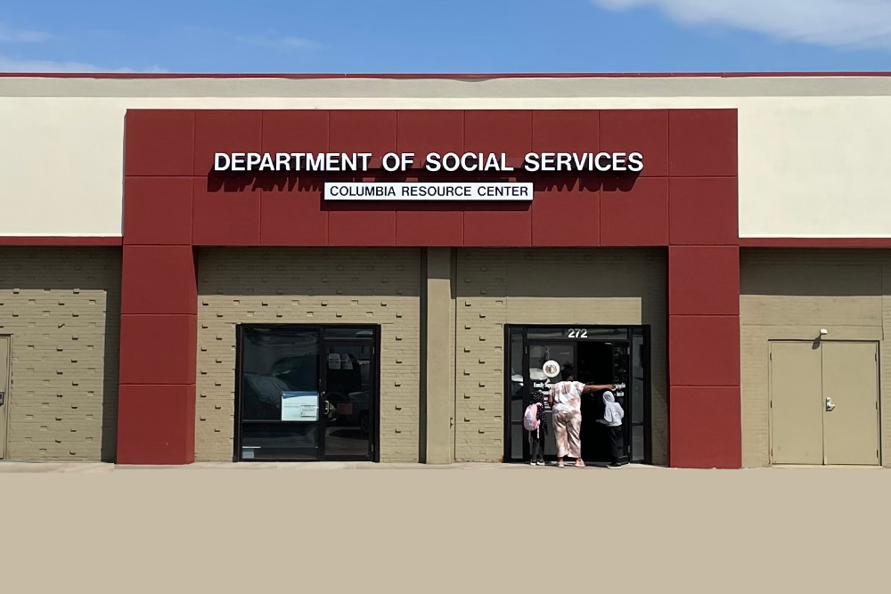 Missouri SNAP_ Red and tan commercial building under a blue sky with signage "Department of Social Services"