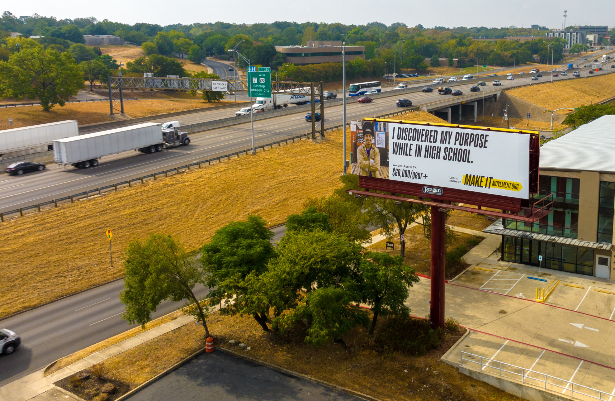 College campaign: Ariel view of freeway going through small town with billboard in foreground with image of person on left side and text "I discovered my purpose while in high school. MakeItMovement $60,000/year+"