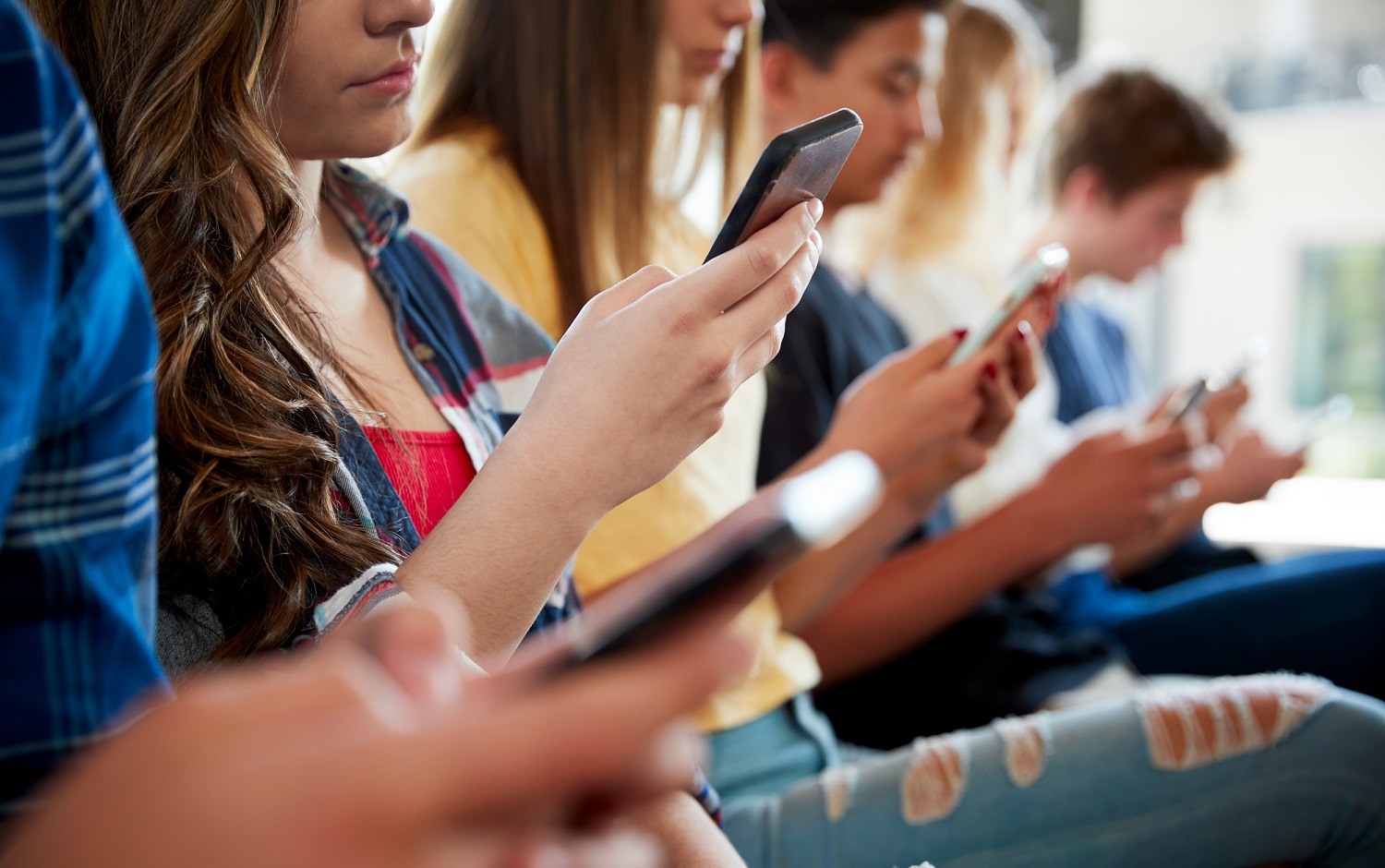 Teens, social media and technology 2023 report: line of teens looking at their phones