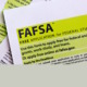 FAFSA paper forms in black ink with lime green boxed highlights on white paper