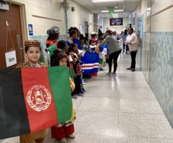Post-COVID school absenteeism: Elemntary students and teachers stand in white school hallway