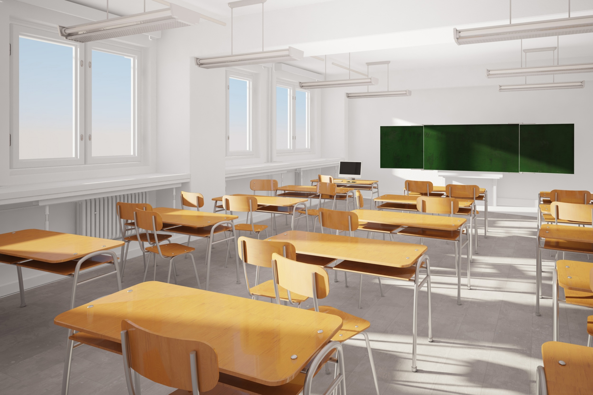 Louisiana school funding: Empty white classroom with rows of light wood desks and chairs facing a blackboard.