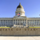 Utah child custody law: Utah state capitol — multi-storied, white, traditional architecture building with large, dark dome and American flag in front.