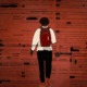 Vague school rules at the root of millions of student suspensions: graphic image of male student with backpack walking away against red background