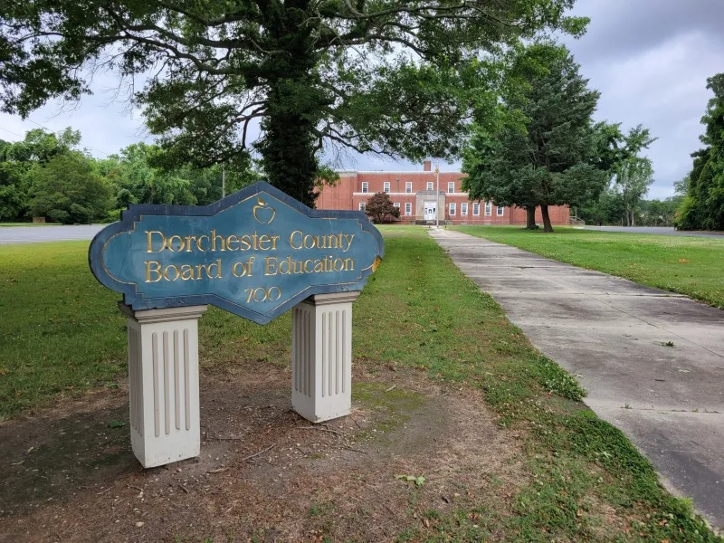 Vague school rules at the root of millions of student suspensions: sign for the Dorchester County Board of Education with walkway extending into the distance toward building