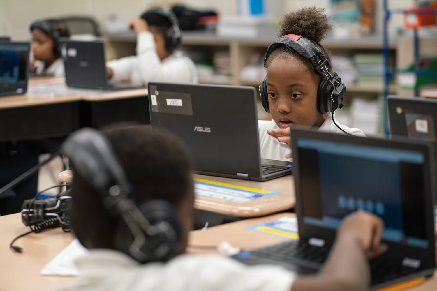 Illinois lawmakers pass 2025 budget: young black female student working on laptop with headphones on in school