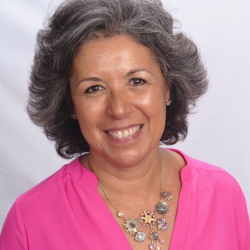 Legal counseling for behavior issues: Headshot of woman with short salt and pepper hair in bright pink top and large necklace