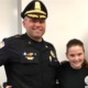 Sandra Birchmore justice: Young teen girl with brown hair pulled back stands smiling next to man in black police uniform and cap with hos arm around the girl's shoulders