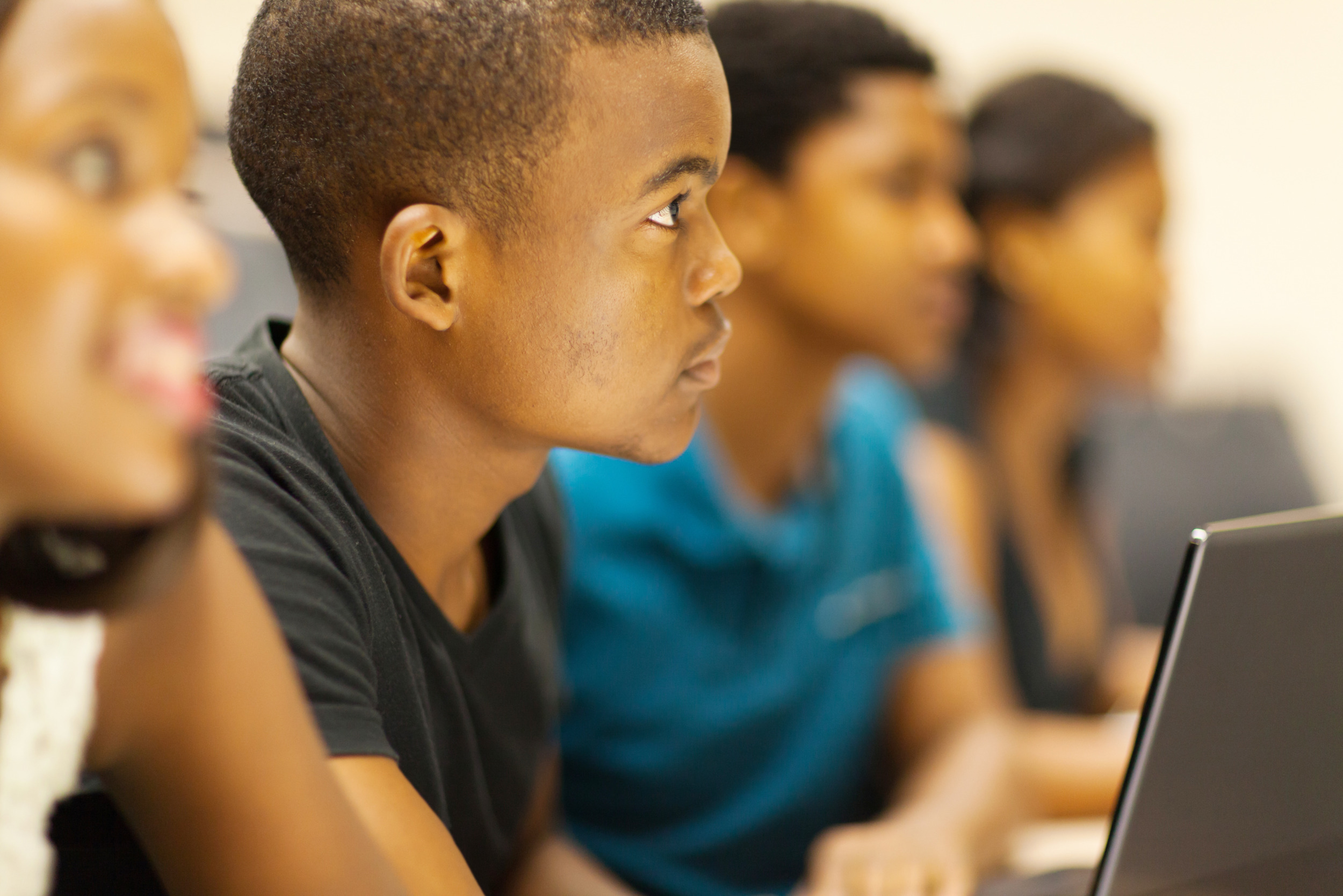 Segregated academies: Four Black students sit in a eow ar laptops