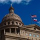 State laws threaten academic freedom in higher education: view looking up at Texas state capitol building with U.S. flag and Texas flag flying