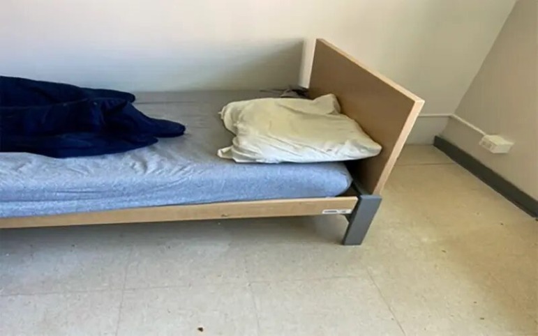 Shrub Oak School investigation: white room with small tin bed with blue sheet and white pillow