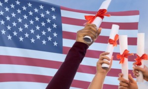 Older Immigrant student school admissions: 5 outstretched arms with hands holding rolled-up document tied with red ribbon against background of American flag