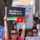 Abortion bans: Close up of crowd of adults at abortion rights rally with signs held up