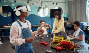 Teens and technology: Students in a school technology classroom using various gear like laptops, VR headsets, and building with electronic kits.