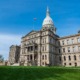 Some Michigan districts are not equitably funding schools with higher needs: view of Michigan capitol building from the front lawn with blue sky