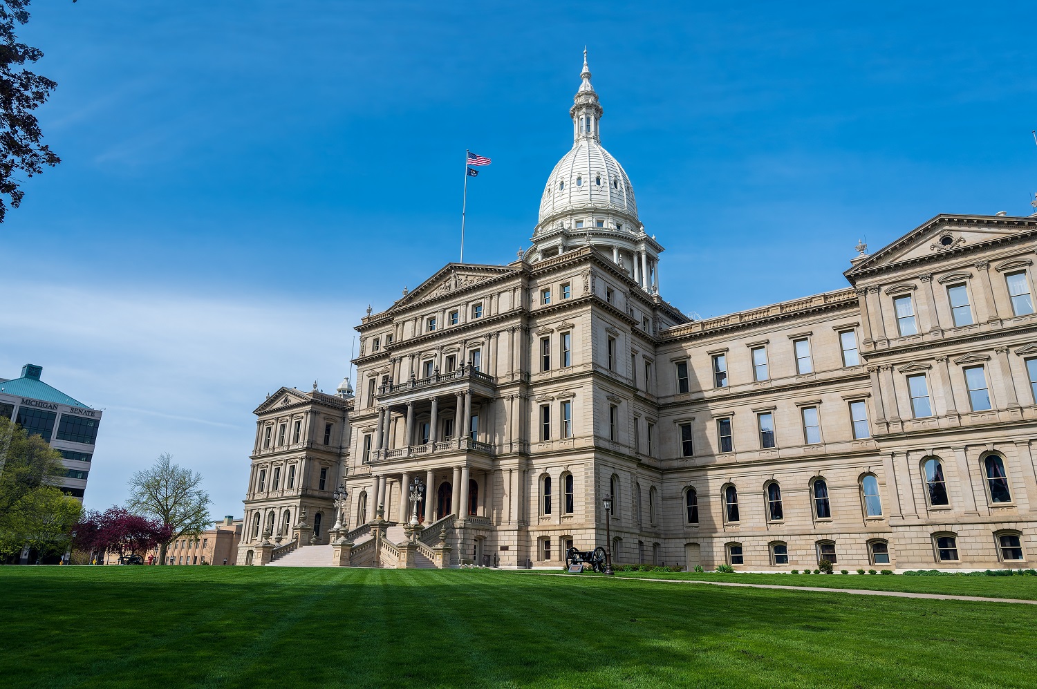 Some Michigan districts are not equitably funding schools with higher needs: view of Michigan capitol building from the front lawn with blue sky